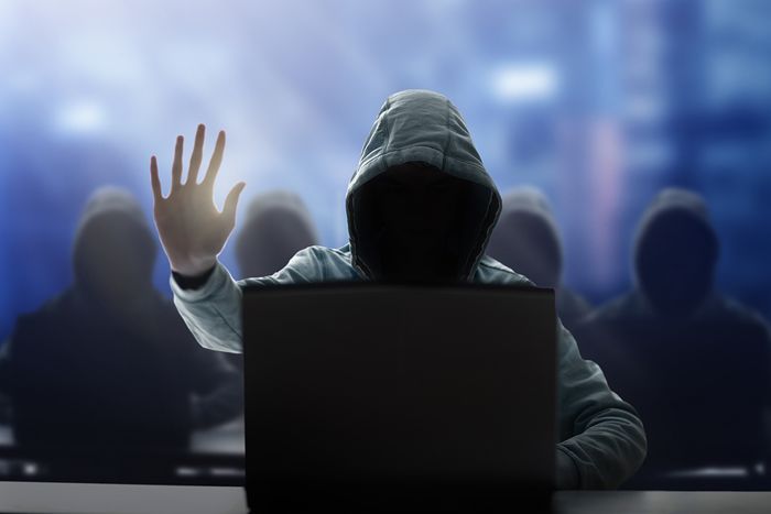 Hooded Man at Laptop - Black Market Betting Concept