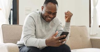 Happy Man Watching Horse Racing on Smartphone