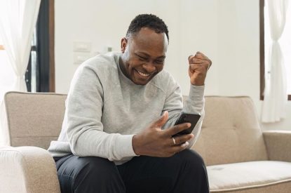 Happy Man Watching Horse Racing on Smartphone