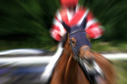 Blurred Jockey Wearing Red and White Silks