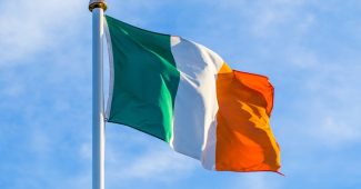 Irish Flag Waving Against Bright Sky