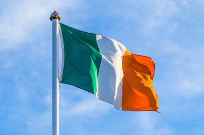 Irish Flag Waving Against Bright Sky