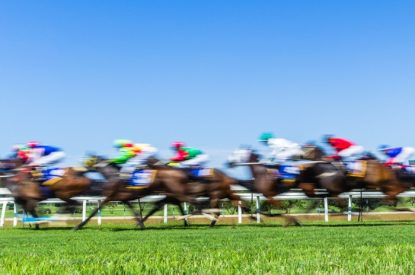 Blurred Field of Horses Against Blue Sky