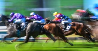 Blurred Horses Racing Past Big Screen