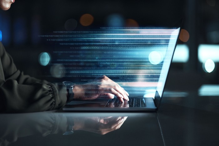 Man Typing on Laptop Showing Digital Data Stream