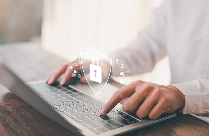 Padlock Shield Hologram Against Man Typing on Laptop