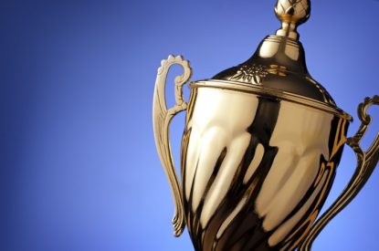 Gold Trophy at Angle Against Blue Background