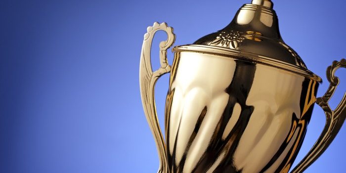 Gold Trophy at Angle Against Blue Background