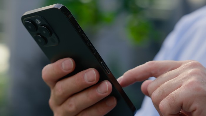 Hands of Man Typing on Smartphone