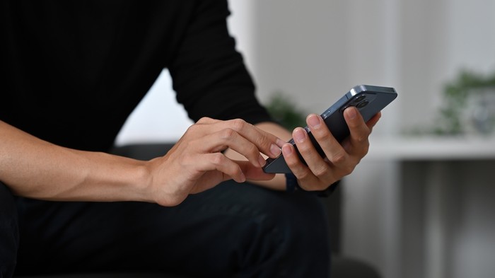 Man Wearing Dark Top Holding Phone