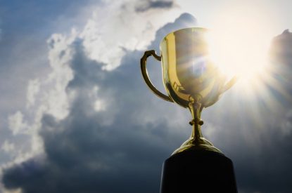 Gold Trophy Against Bright Cloudy Sky